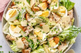 Grilled chicken Caesar salad topped with creamy dressing and croutons