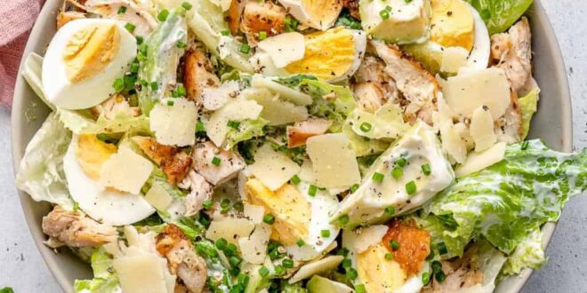 Grilled chicken Caesar salad topped with creamy dressing and croutons