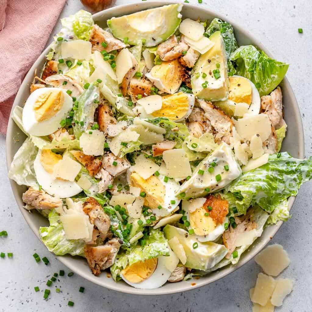 Grilled chicken Caesar salad topped with creamy dressing and croutons