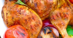 Tender grilled whole chicken served on a platter with herbs