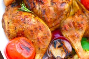 Tender grilled whole chicken served on a platter with herbs
