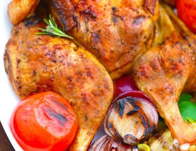Tender grilled whole chicken served on a platter with herbs