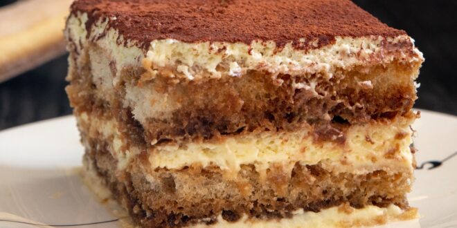 Delicious tiramisu dessert topped with cocoa and cream